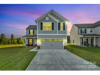 Beautiful two-story home featuring a gray exterior, a two-car garage, and a well-manicured lawn at 112 Aspire Cir, Wingate, NC 28174