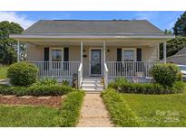 Charming home featuring a covered front porch, manicured lawn, and inviting curb appeal at 113 Ervin St, Belmont, NC 28012