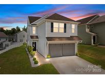Charming two-story home with a well-manicured lawn, walkway lights, and an attached two-car garage at 1207 Skyflower Way, Charlotte, NC 28214