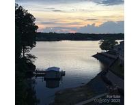 Picturesque lake view at sunset, complete with a boathouse and tranquil waters at 14608 Waterside Dr, Charlotte, NC 28278