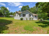 Charming painted brick ranch-style home with manicured lawn and inviting curb appeal at 14821 Cumberland Dr, Charlotte, NC 28227