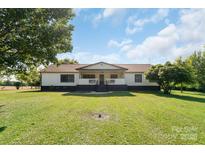 Charming single-story home with inviting front porch and expansive green lawn at 1909 Mountain Springs Church Rd, Monroe, NC 28112