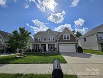 Charming two-story home boasts beautiful curb appeal, a well-maintained lawn, and an attached two-car garage at 2577 Shoal Park Rd, Concord, NC 28027
