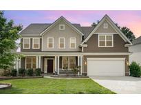 Charming two-story home with covered front porch, manicured lawn and attached two-car garage at 2577 Shoal Park Rd, Concord, NC 28027