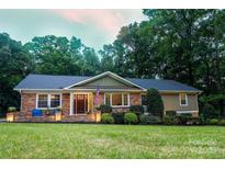 Charming brick home with a well-manicured lawn and cozy porch at 327 Whitestone Rd, Charlotte, NC 28270
