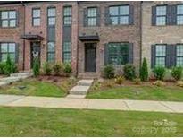 Charming brick townhome featuring well-maintained landscaping and a welcoming entryway, providing an inviting curb appeal at 416 Linestowe Dr, Belmont, NC 28012