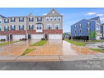 Charming townhome exterior with brick accents, gray siding, and inviting curb appeal on a wet day at 416 Moondance Dr # 121, Gastonia, NC 28054
