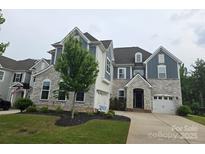 Beautiful two-story home featuring stone accents, a well-manicured lawn, and a two-car garage at 5000 Britannia Blvd, Waxhaw, NC 28173
