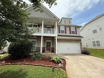Charming two-story home features a covered porch, red shutters, and a two-car garage at 5111 Elementary View Dr, Charlotte, NC 28269