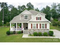 Charming two-story home with stone accents, inviting front porch, and well-manicured lawn at 512 Rosebush Ln, Clover, SC 29710
