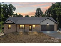 Charming brick home featuring an attached garage, covered front porch and neutral trim details at 5526 Brookwood Ln, Hickory, NC 28602