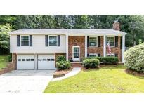 Charming brick and vinyl home with a well-manicured lawn and an attached two-car garage at 5909 Ryder Ave, Charlotte, NC 28226