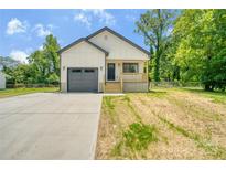 Charming new build features a front porch, modern garage door, and freshly poured concrete driveway at 707 W Davidson Ave, Gastonia, NC 28052