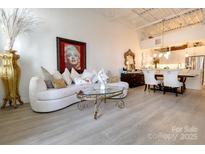 Bright living room features an off-white sofa, decorative accessories, and kitchen in the background at 720 Governor Morrison St # 221, Charlotte, NC 28211