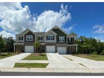 New townhome construction with brick accents, individual driveways and garage doors, and varied neutral color schemes at 8060 Scarlet Maple Ln, Tega Cay, SC 29708