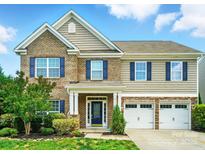 Charming two-story home featuring brick and siding exterior, blue shutters, and a two-car garage at 8115 Kelburn Ln, Charlotte, NC 28273