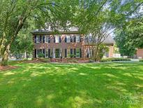 Charming two-story brick home with black shutters and a well-manicured front lawn at 9622 Penshurst Trce, Charlotte, NC 28210