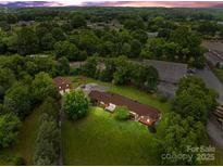 Expansive property featuring a brick home, additional brick building, and a barn surrounded by lush greenery at 10637 Highway 52 Hwy, Rockwell, NC 28138
