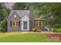 Charming gray brick home with a quaint teal front door and well-manicured lawn at 1106 S South St, Gastonia, NC 28052