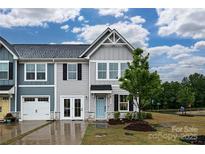 Charming townhome featuring a light blue front door, manicured lawn, and stone accents at 124 Kristin View Ln # Townhome A, Troutman, NC 28166