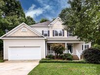 Charming two-story home with manicured front lawn, attached two-car garage, and inviting front porch at 1423 Piper Ct, Concord, NC 28025