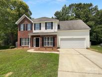 Charming two-story home featuring a brick and vinyl facade, attached two car garage, and a well-maintained lawn at 1523 Merrie Meadow Ct, Rock Hill, SC 29732