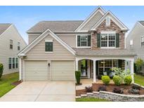 Charming two-story home featuring a stone facade, two-car garage, and welcoming front porch at 18522 Victoria Bay Dr, Cornelius, NC 28031