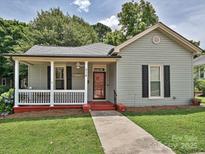 Charming home features a inviting front porch, walkway, manicured lawn, and traditional architecture at 214 Tenth St, Cramerton, NC 28032