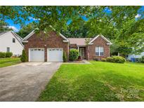 Charming brick home with a well-manicured lawn and a two-car garage at 256 Rose St, Mooresville, NC 28117