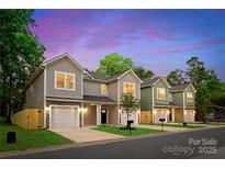 Charming new construction townhomes showcasing craftsman style architecture, garages, and landscaped yards at 2723 Capitol Dr, Charlotte, NC 28208