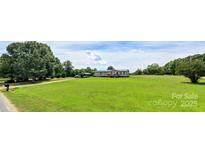 A charming single-story home with a large front yard and ample space for outdoor activities at 302 Edwards Rd, Mooresville, NC 28115