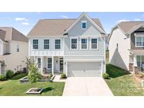 Charming two-story home with light blue siding, white trim, and a welcoming two-car garage at 3038 Burnello Ct, Iron Station, NC 28080