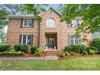 Charming brick two-story home featuring a landscaped front yard, black shutters, and classic architectural details at 4808 Cobble Glen Way, Charlotte, NC 28269