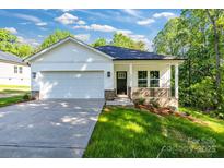 Charming single-story home featuring a two-car garage, inviting front porch, and manicured lawn at 5175 Grand Canyon Rd, Concord, NC 28027
