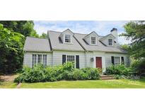 Charming home with dormer windows, red front door, and lush greenery in the front yard at 600 College Ave, Rock Hill, SC 29730
