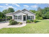Charming one-story home featuring a gray exterior, well-manicured lawn, and a convenient carport at 613 Gold Hill Dr, Salisbury, NC 28146