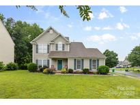 Charming two-story home with a well-manicured lawn and lush landscaping at 9637 Brookmere Ln, Charlotte, NC 28214