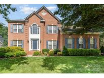 Charming brick two-story home with well-manicured lawn and blue shutters for a classic and inviting curb appeal at 1002 Hollyhedge Ln, Indian Trail, NC 28079