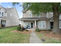 Charming two-story townhome with covered porch and landscaped front yard offering great curb appeal at 1012 Laparc Ln, Indian Trail, NC 28079