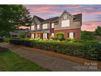 Beautiful two-story home featuring brick and stone accents, a covered porch, and mature landscaping at 126 Northbridge Dr, Mooresville, NC 28115