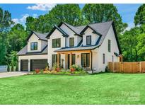 Beautiful white two-story home with black trim, manicured lawn, and colorful flowerbeds at 140 Robin Rd, Lincolnton, NC 28092