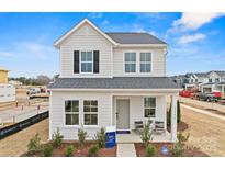 Charming two-story home with gray siding, black shutters, and a welcoming front porch at 15906 Parkside Crossing Dr # 317, Charlotte, NC 28273