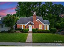 Charming brick home with a well-manicured lawn and mature trees at 2100 Chesterfield Ave, Charlotte, NC 28205