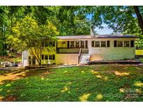 Charming painted brick home with a cozy porch and mature trees surrounding the property at 2229 Old Wilkesboro Rd, Statesville, NC 28625