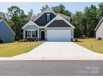 Charming two-story home with a two-car garage and well-manicured lawn at 2921 Parkwest Dr, Albemarle, NC 28001