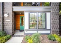 Inviting entryway with modern brick, stylish trim, a green door, and large window at 3026 Kalex Ct, Charlotte, NC 28204