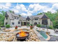 Stunning backyard featuring a stone patio with a fire pit, swimming pool, lounge chairs, and outdoor seating at 3587 Ridgetop Rd, Sherrills Ford, NC 28673