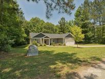 Charming ranch home with lush landscaping, inviting front yard and attached two-car garage at 429 Summer Ridge Dr, Stanley, NC 28164