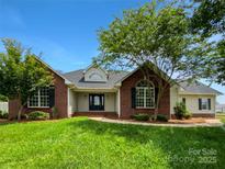 Charming brick home featuring mature trees, well-maintained lawn, and inviting front entrance at 4550 Briarcreek Rd, Maiden, NC 28650
