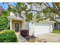 Charming home featuring a brick-accented entrance, vinyl siding, a two-car garage, and beautiful flowering trees at 78114 Rillstone Dr, Lancaster, SC 29720